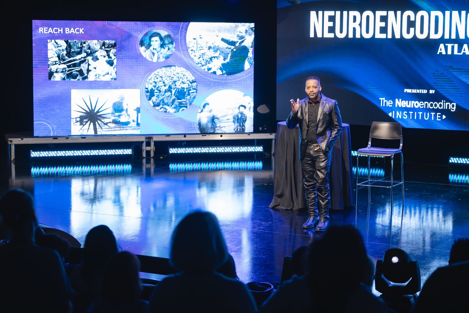 Dr. Stephen J. Crawford presenting on stage at a NeuroEncoding Institute event