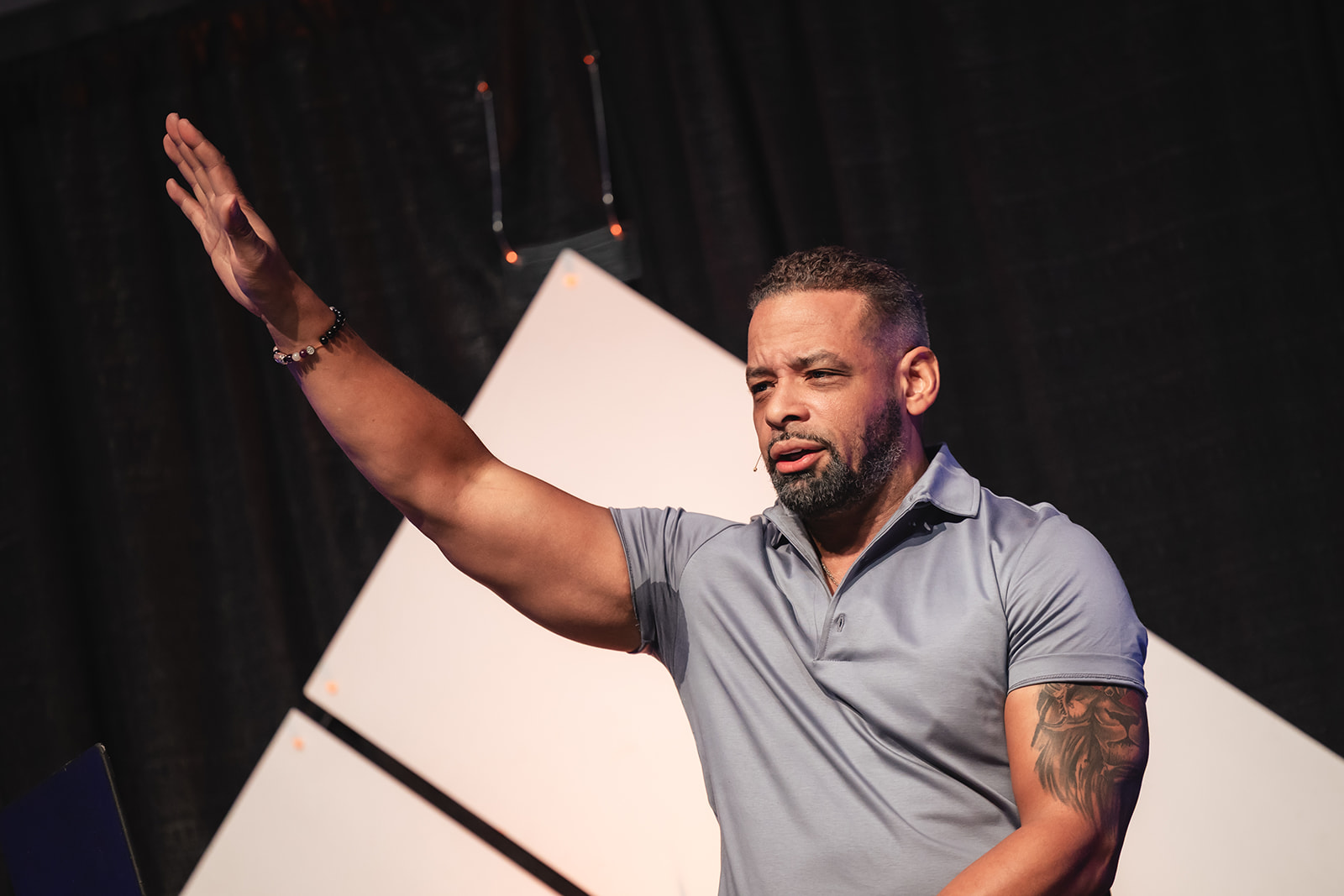 Dr. Stephen Crawford speaking confidently on stage with one hand raised