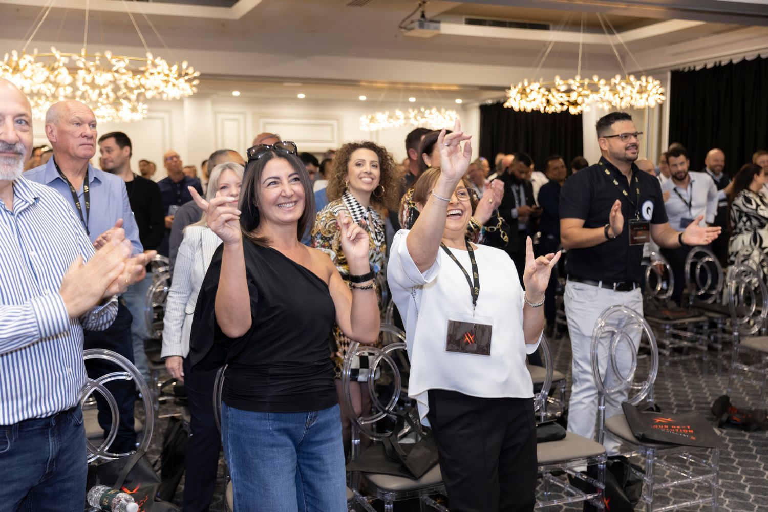 Audience members applauding in a conference room after a leadership keynote